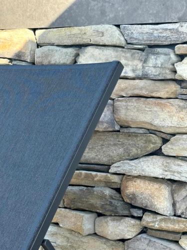 a black sign on the side of a stone wall at Le Clos Vercheron in Artaix