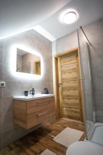 a bathroom with a sink and a shower at Pokoje Gościnne Fuksja in Nowęcin