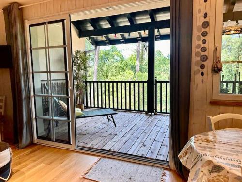 une véranda avec une porte coulissante en verre dans l'établissement Charme & Nature - 2 chambres, cosy, Lac, Golf, Piscine, Terrasse, Parking, 2 à 5 pers max, à Biscarrosse