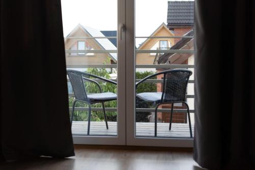 an open door with two chairs on a balcony at Pokoje Gościnne Fuksja in Nowęcin