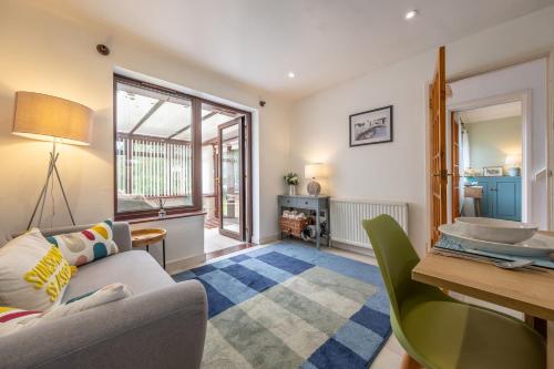 a living room with a couch and a table at Ash Tree Cottage in West Runton