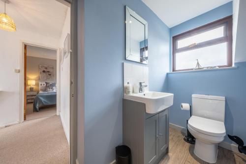 a bathroom with a white toilet and a sink at Ash Tree Cottage in West Runton