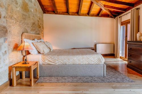 a bedroom with a bed and a table with a lamp at Casa Lata - Agroturismo e Enoturismo in Amares