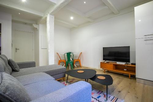 un salon avec un canapé et une télévision dans l'établissement Appartement T2 - Castellane/Cours Julien (climatisation et terasse), à Marseille