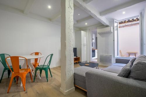 un salon avec un canapé, une table et des chaises dans l'établissement Appartement T2 - Castellane/Cours Julien (climatisation et terasse), à Marseille