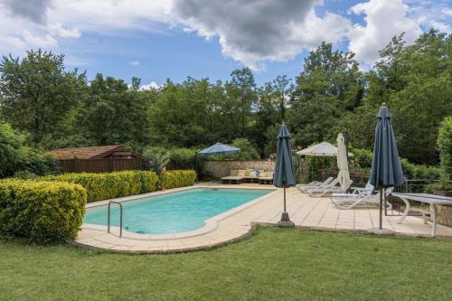 a swimming pool with umbrellas in a yard at Guest House - Azienda Oddone Prati in Strevi