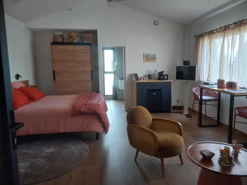 a bedroom with a bed and a table and a kitchen at La lagune aux oiseaux in Palavas-les-Flots
