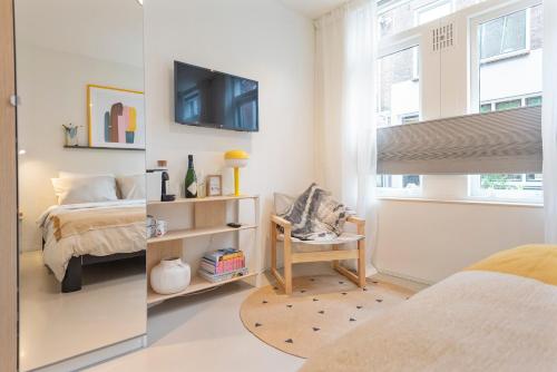 a bedroom with a bed and a tv on the wall at Studio Carlos in Haarlem