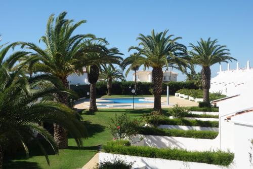 a resort with palm trees and a swimming pool at Moradias Villas Joinal in Albufeira