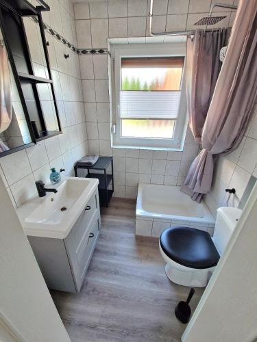 a bathroom with a sink and a toilet and a window at Ferienwohnung Karlson in Wilhelmshaven