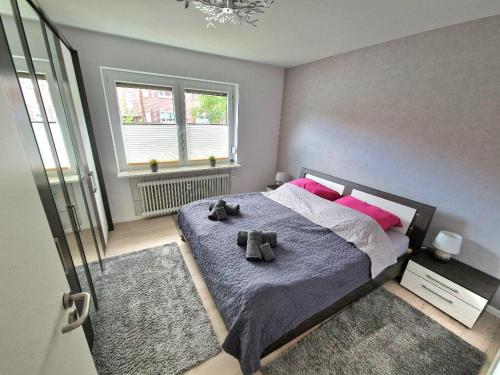 a bedroom with a bed with two stuffed animals on it at Ferienwohnung Karlson in Wilhelmshaven