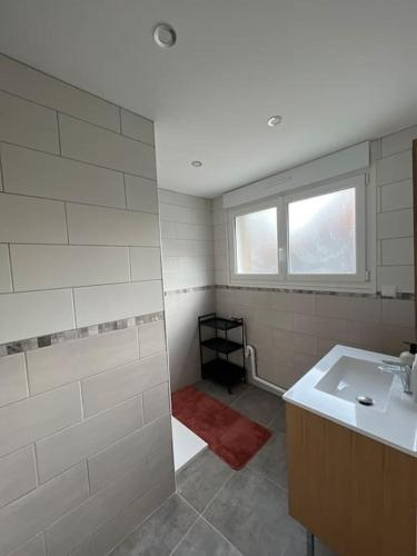 a bathroom with a shower and a sink and a window at La Maison Saint-Adrien in Boulogne-sur-Mer