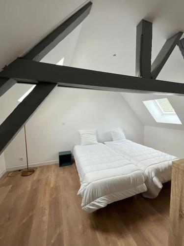 a white room with a bed in a attic at La Maison Saint-Adrien in Boulogne-sur-Mer