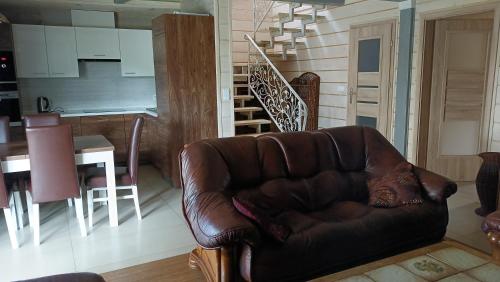 a brown leather couch sitting in a living room at Willa Myśliwska dom 10-osobowy ZE STREFĄ BASENOWĄ w miejscowości Chocznia NIEDALEKO ZATORU I ENERGYLANDII in Chocznia