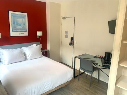 Un dormitorio con una cama y un escritorio con una computadora. en Hipotel Belgrand Edith Piaf, en París