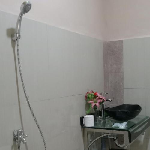 a bathroom with a shower and a sink at Rezka Roomz Syari'ah in Ende