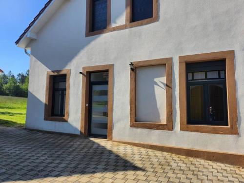 a house with two doors and windows on it at Loft spacieux en pleine forêt in Bining-lès-Rohrbach