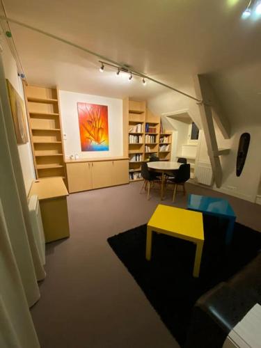 d'un salon avec une table et une peinture murale. dans l'établissement Appartement cosy - Dinan centre, à Dinan