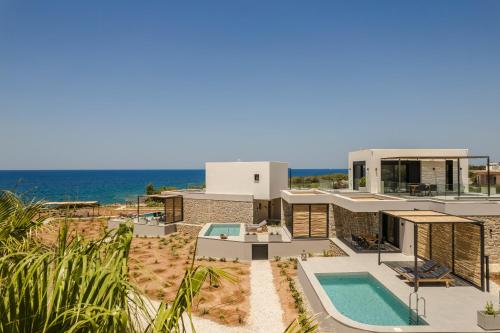 a house on the beach with a swimming pool at Mast Luxury Residences in Gargaliánoi