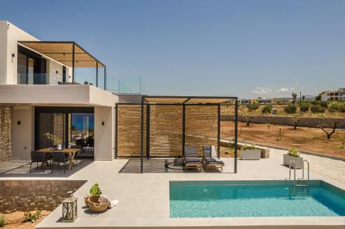 a villa with a swimming pool in front of a house at Mast Luxury Residences in Gargaliánoi