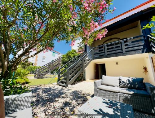 une terrasse avec un canapé et un arbre dans l'établissement Havre de paix à Saint Cyprien à 300m de la plage, à Saint-Cyprien