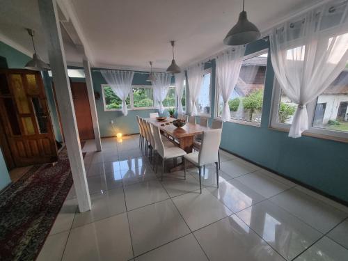 een eetkamer met een tafel, stoelen en ramen bij Agroturystyka Nienasycenie in Brzeźno Łyńskie