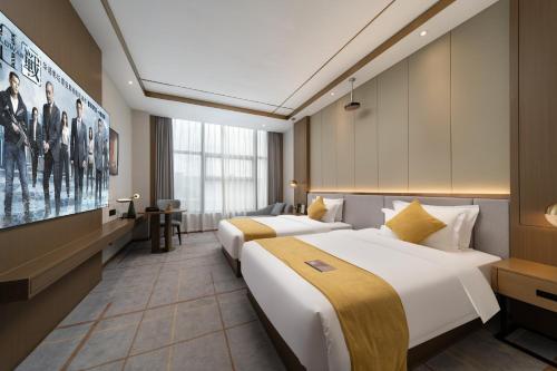 a hotel room with two beds and a tv at Poltton International Service Apartments - Zhuhai Gongbei Port Fuhuali铂顿国际公寓珠海拱北口岸富华里店 in Wan-tzu