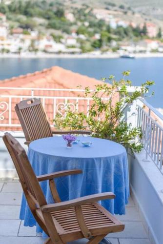 a table and chairs on a balcony with a view of the water at Agia Efimia seaside 2br apartment in Agia Effimia