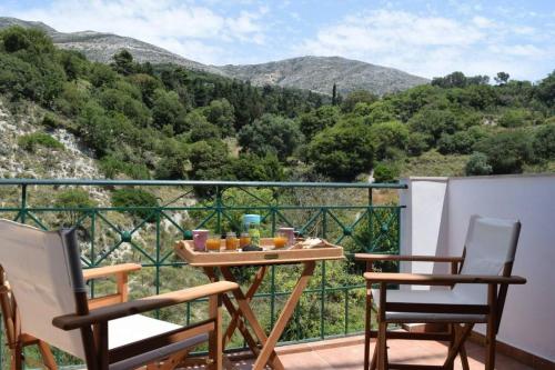 a balcony with two chairs and a table with food on it at Villa Verde in Divarata in Divarata