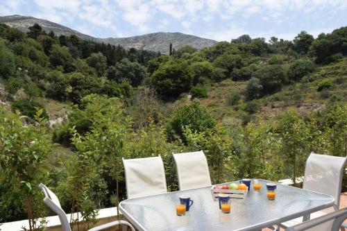 a table and chairs with drinks on top of a mountain at Villa Verde in Divarata in Divarata