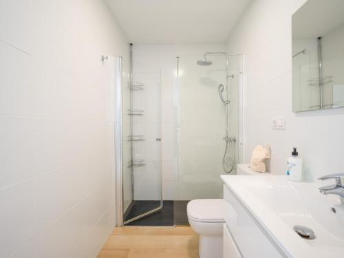 a white bathroom with a shower and a toilet at Beyond Amadores 11 in Mogán