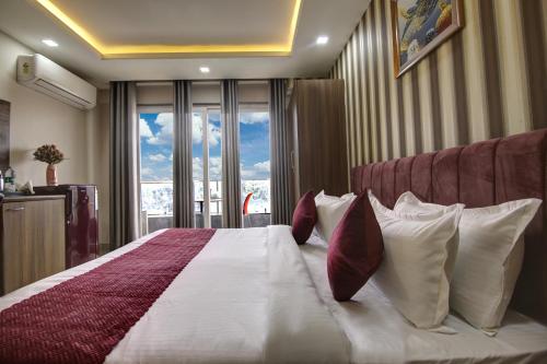 a bedroom with a large bed with pillows and a window at Limewood Stay Silver Studio Near Golf Course Road in Gurgaon