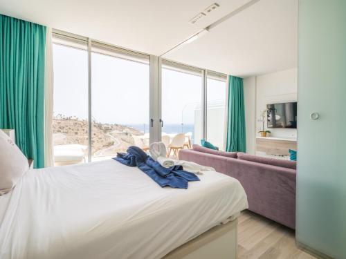 a bedroom with a large bed and a couch at Beyond Amadores 11 in Mogán