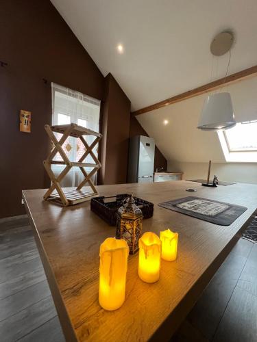 a room with a table with yellow candles on it at Loft spacieux en pleine forêt in Bining-lès-Rohrbach