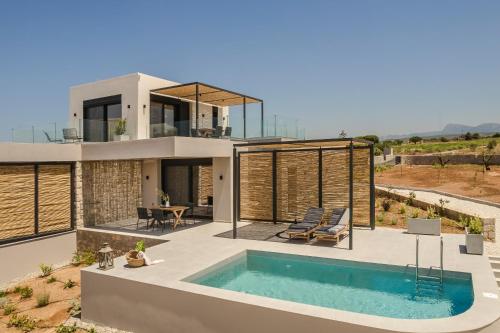 a house with a swimming pool in front of it at Mast Luxury Residences in Gargaliánoi
