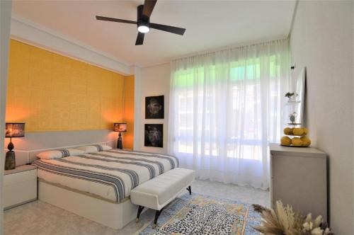 a bedroom with a bed and a ceiling fan at Amazing beach apartment in Cullera