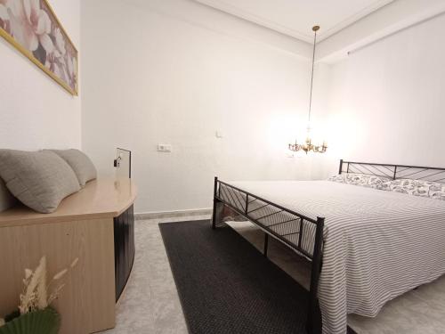 a bedroom with a bed with a black and white comforter at Amazing beach apartment in Cullera
