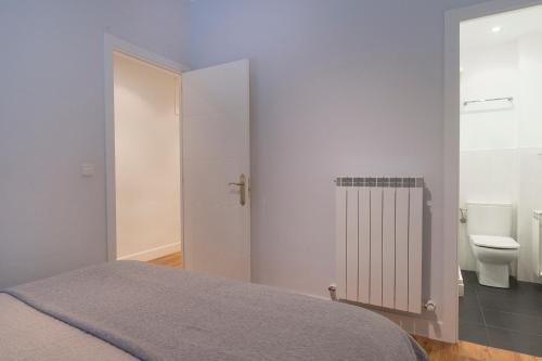 1 dormitorio con 1 cama y baño con aseo en Playa Gros - IB. Apartments, en San Sebastián