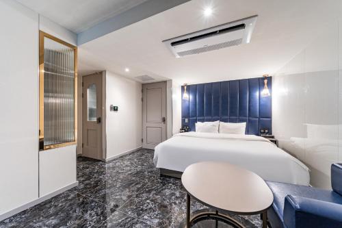 a bedroom with a bed and a table and a chair at Hotel Voll in Seoul
