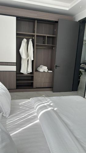 a bedroom with a large white bed and a closet at Infinity Villas 1 Superking bed Studio Apartment free parking , WiFi , 24 hr security in Entebbe