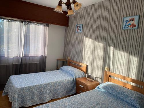 a bedroom with two beds and a window at Casa Portomeiro in San Román