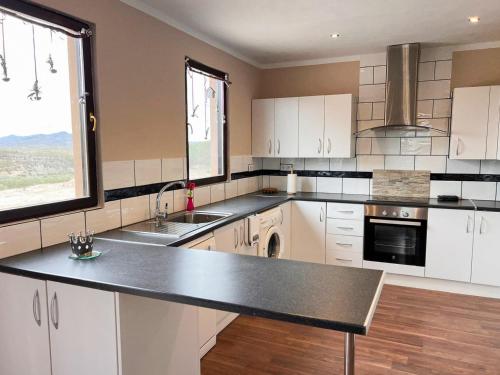 a kitchen with white cabinets and a black counter top at CASA LEÓN - Freistehendes Gästehaus mit 3 Zimmer, Vivienda Rural VTARAL01089 in Sorbas