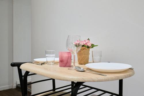 une table avec une assiette, des verres et des fleurs dans l'établissement NG Prestige l Lille l Tourcoing - Bouvines - Balnéo & Cuisine, à Tourcoing