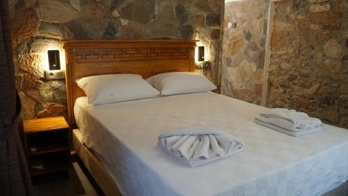 a bedroom with a bed with two towels on it at Pikan Ephesus in Selcuk