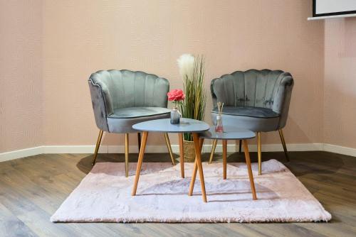 deux chaises et une table dans une pièce dans l'établissement NG Prestige l Lille l Tourcoing - Bouvines - Balnéo & Cuisine, à Tourcoing