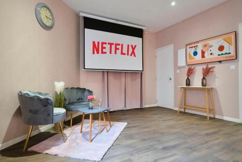 une salle d'attente avec un panneau netflix sur le mur dans l'établissement NG Prestige l Lille l Tourcoing - Bouvines - Balnéo & Cuisine, à Tourcoing