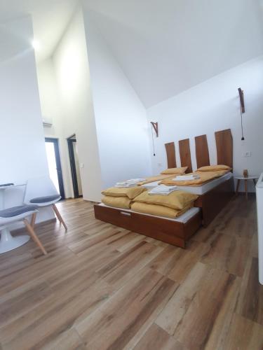 a bedroom with two beds and a wooden floor at Smeštaj Skuratenko in Malo Laole