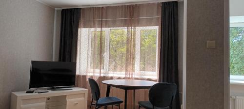 a room with a table and a television and a window at City Center Turu str apartments, parking, Tartu Home in Tartu