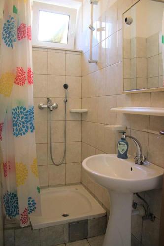 a bathroom with a shower curtain and a sink at Apartments Pidi in Neum