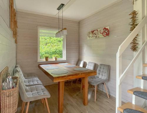 a dining room with a wooden table and chairs at FH "Gestiefelter Kater" am See im hessischen Bergland in Kirchheim